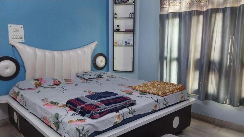 Una cama en un dormitorio con una pared azul. en Kashi Heritage, en Varanasi