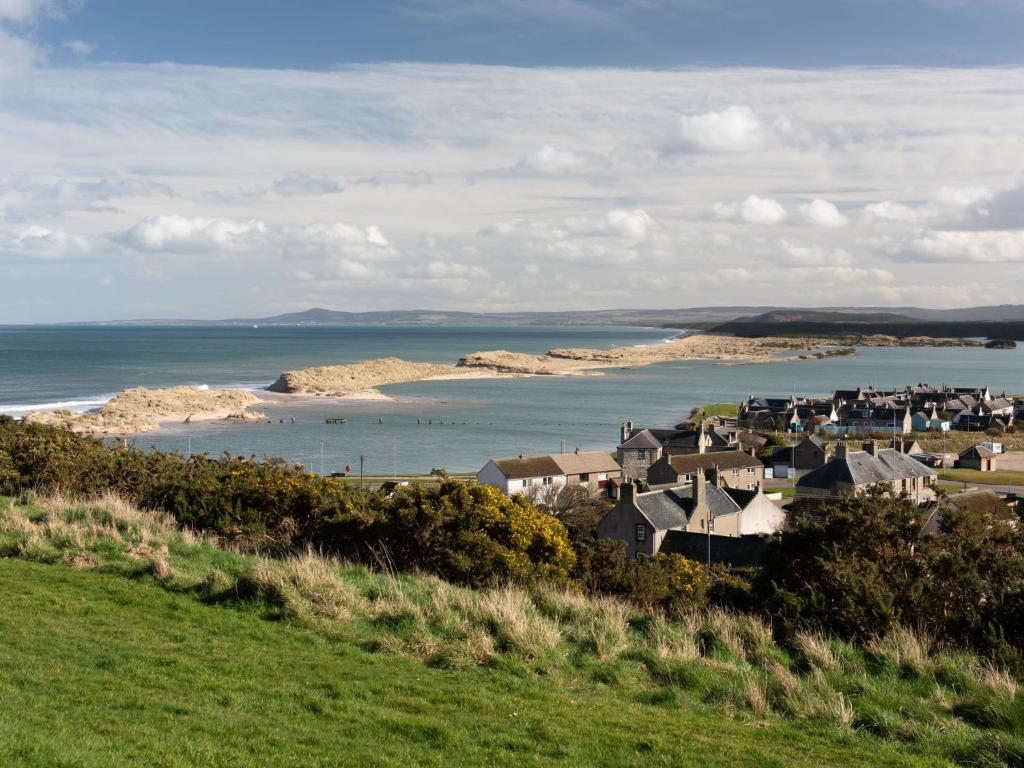 a group of houses on a hill next to the ocean at Apartment Harbour Nights 7E by Interhome in Lossiemouth