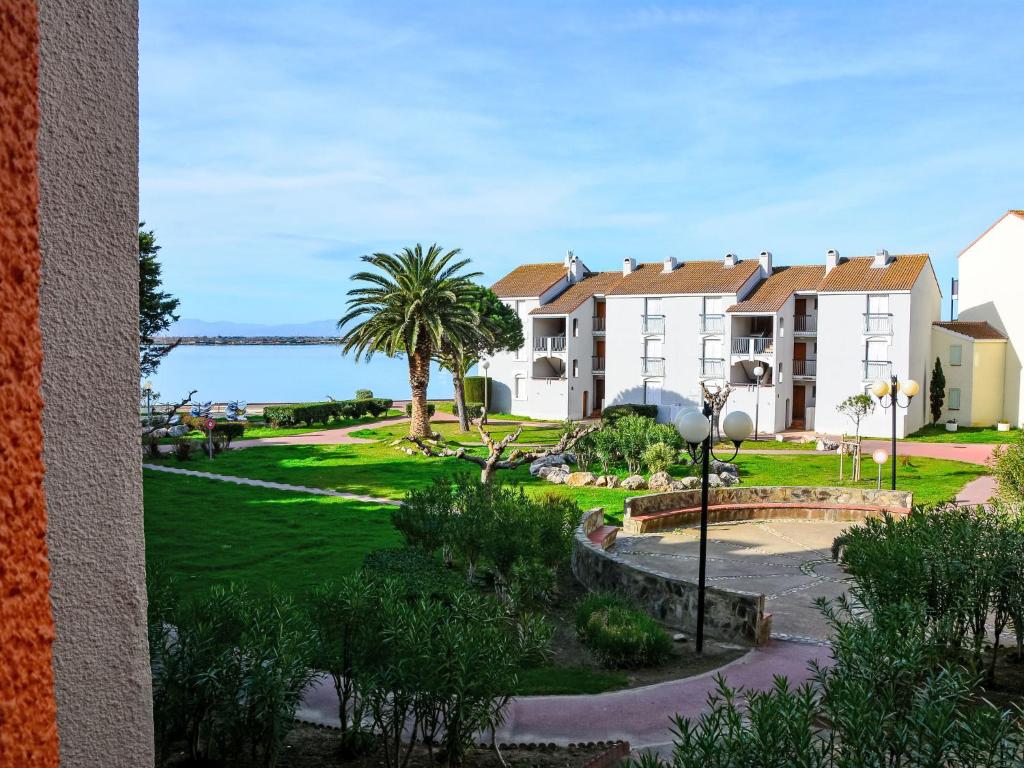 Une rangée de maisons avec des palmiers et l'océan dans l'établissement Apartment Dominica-4 by Interhome, au Barcarès