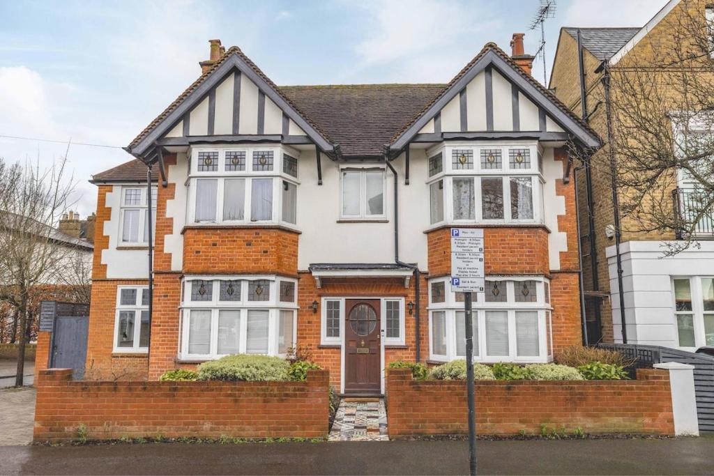 a red brick house with a sign in front of it at Spacious 5BR Home, Parking, Walk to Windsor in Windsor