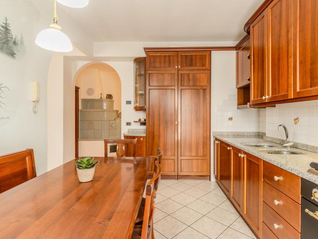 a kitchen with wooden cabinets and a wooden table at Apartment Vento Alpino-3 by Interhome in Predaia