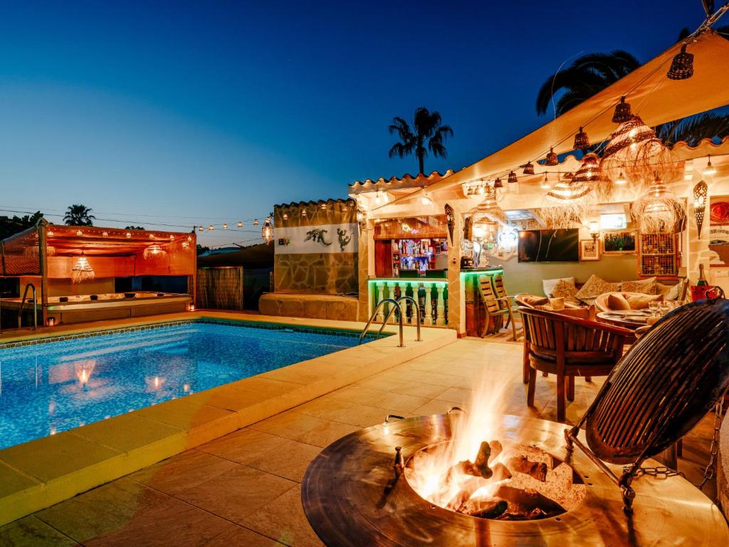 einen Pool mit einer Feuerstelle neben einem Haus in der Unterkunft Holiday Home Villa Cristina by Interhome in Jávea