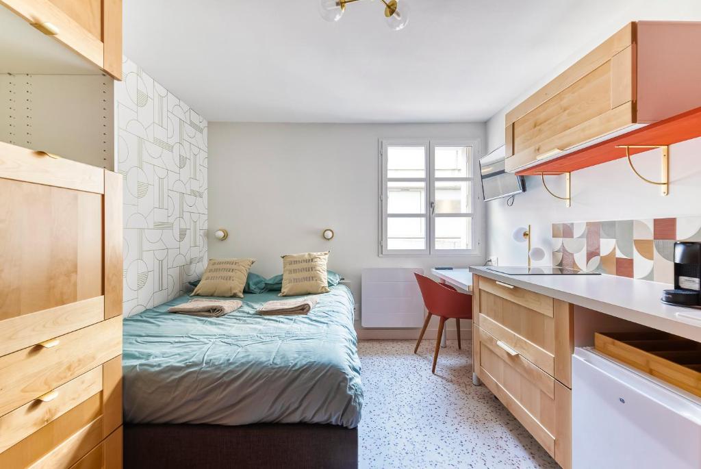 アンジェにあるLa bulle Place du Ralliementのベッドと机のある小さな寝室