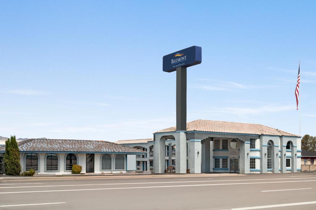 a sign on a pole in front of a building at Baymont by Wyndham Kingman in Kingman