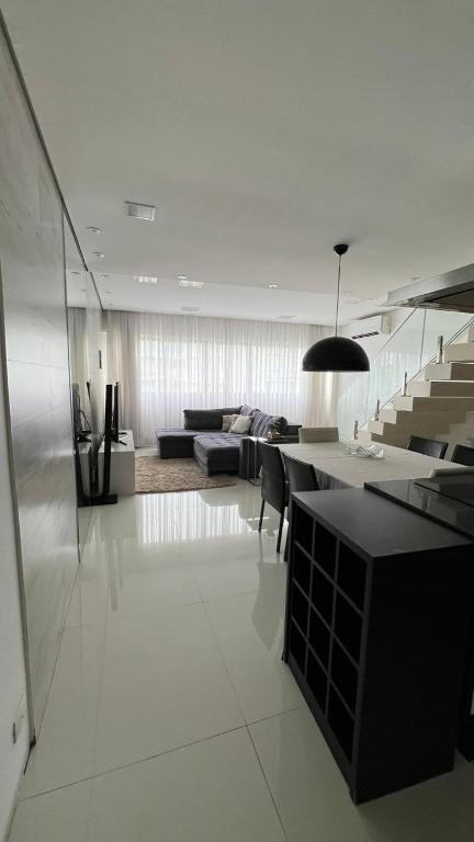 a kitchen and living room with a table and a couch at Apartamento de luxo no Guaruja in Guarujá