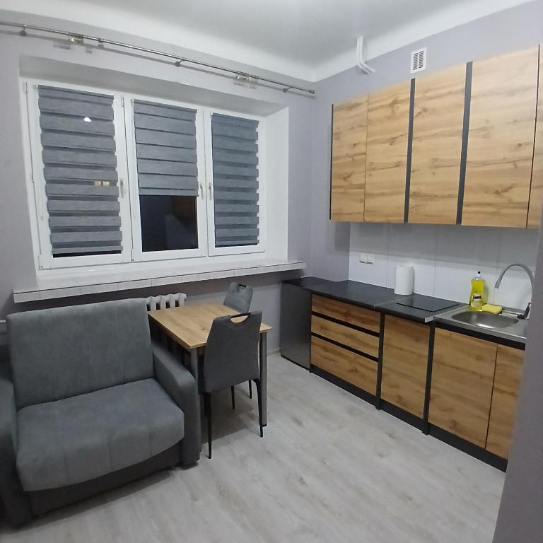 a kitchen with a table and a chair and a sink at Mała kawalerka Kraśnik in Kraśnik