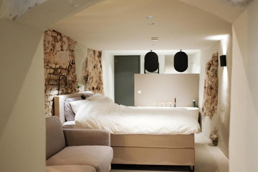 1 dormitorio con cama blanca y sofá en Domnacht aan de gracht, en Utrecht