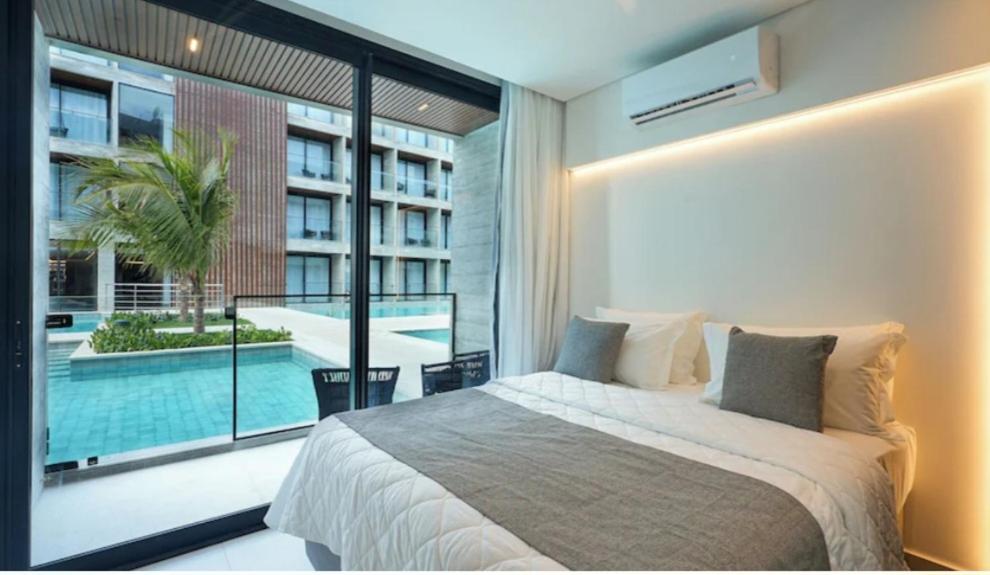 a bedroom with a large bed and a swimming pool at GAV Porto Alto Resorts in Ipojuca