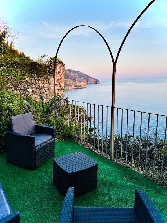 a patio with chairs and a view of the ocean at Il Grecale - The Cliff Retreat in Corniglia
