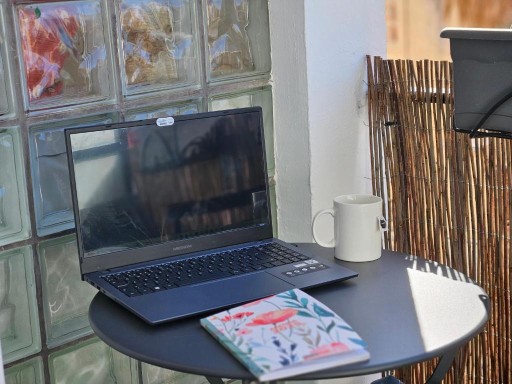 einen Laptop auf einem Tisch mit einer Kaffeetasse in der Unterkunft Urban loft Valencia playa in Puebla de Farnals