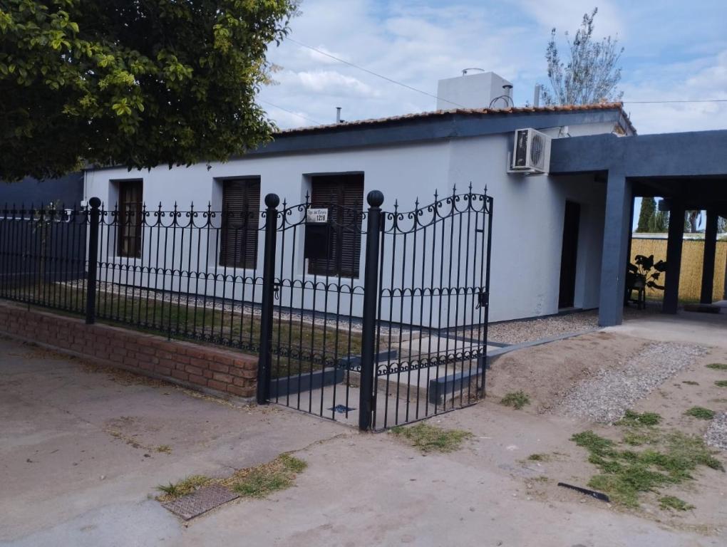 a white house with a black fence at La Casita de Lucía in Almafuerte