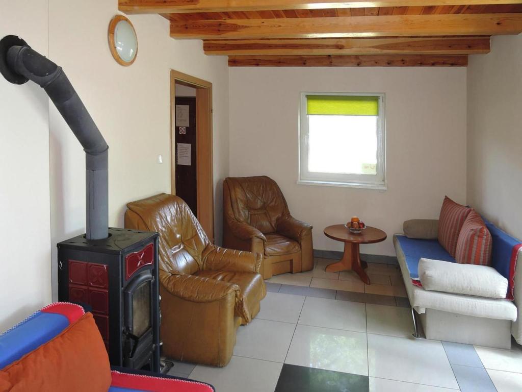 a living room with a wood stove and leather chairs at Apartment in Szczecin near Puszcza Bukowa in Szczecin