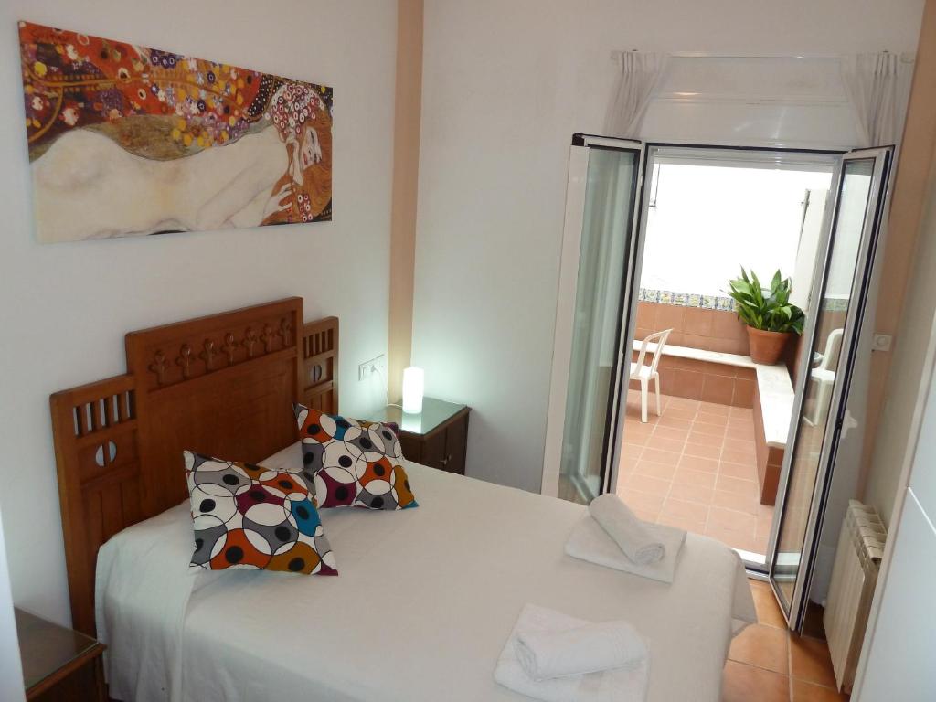 塞維利亞的住宿－Karmapartment，一间卧室设有一张床,享有阳台的景色