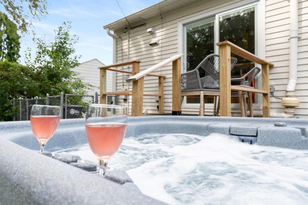 two glasses of wine in a hot tub at Peaceful Gem HotTub Fenced Yard & Near Downtown in Omaha