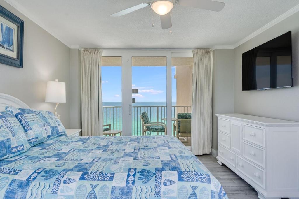 a bedroom with a bed and a view of the ocean at Dunes of Panama 1506 in Panama City Beach