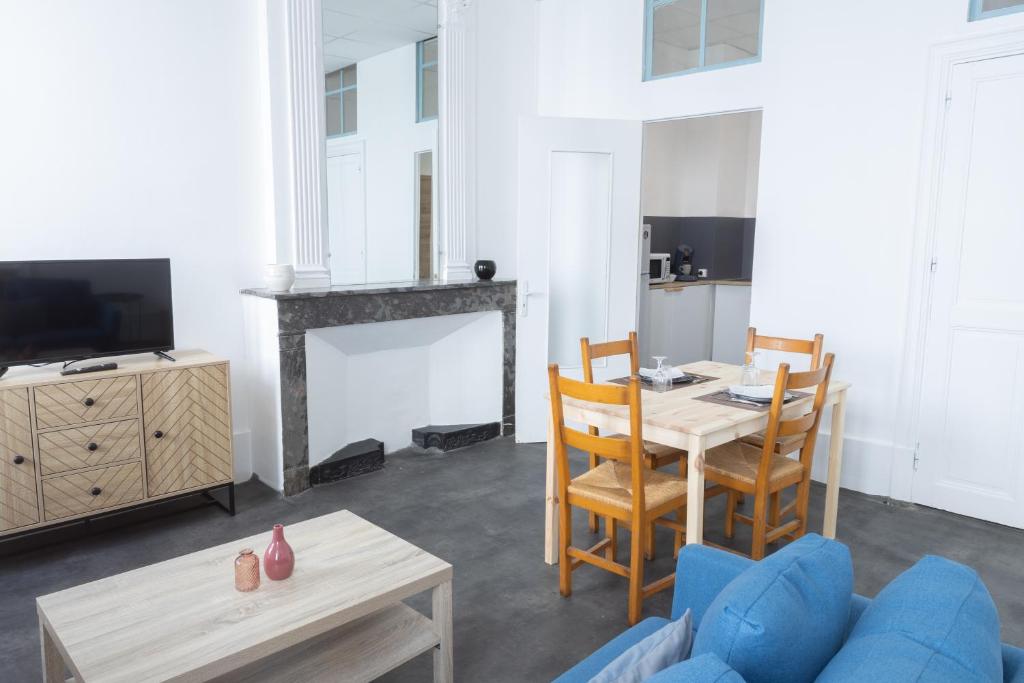 un salon avec une table et une cheminée dans l'établissement Havre Doux - TV, Wifi, Élégant - Centre Ville, à Montélimar