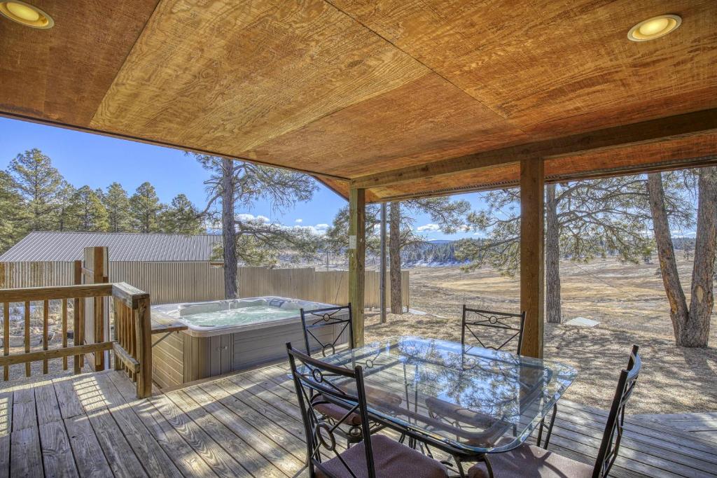 una terrazza con vasca idromassaggio, tavolo e sedie. di 811 County Rd 500 a Pagosa Springs