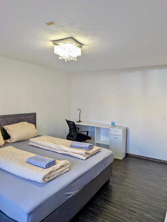 a room with two beds and a desk in it at SiYen three with 24h Check-in in Ammerbuch