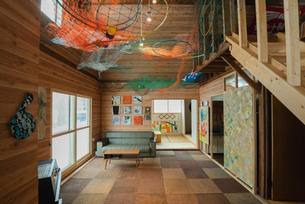 a living room with a couch and wooden walls at アルテミナガハク in Teshikaga