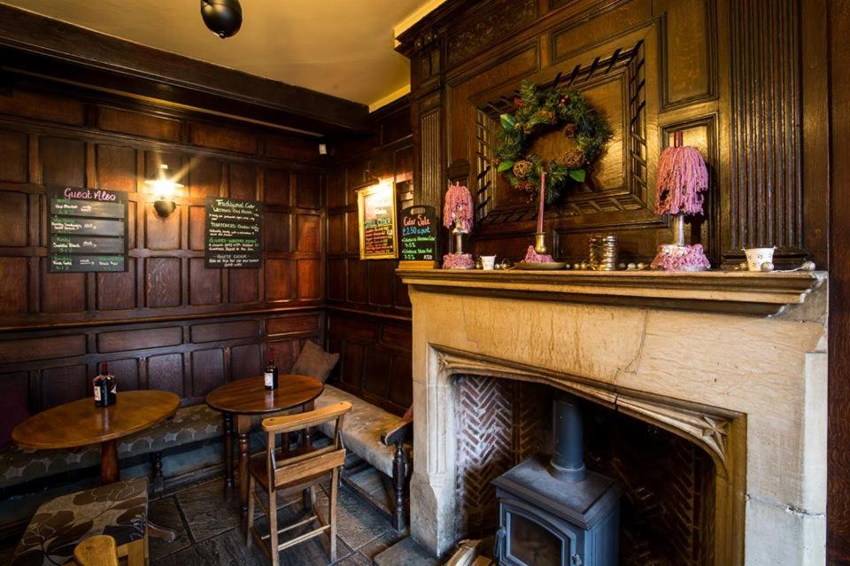 a fireplace in a pub with two tables and a fire place at The Cardinals Hat in Worcester