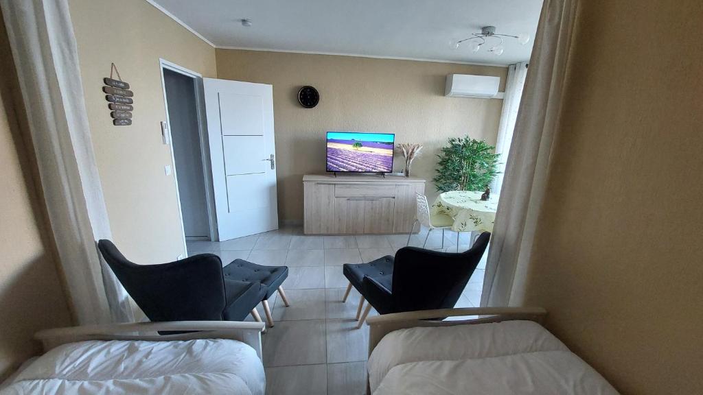 Cette chambre dispose de 2 chaises et d'une télévision. dans l'établissement Le studio Belle Viste, à Gréoux-les-Bains