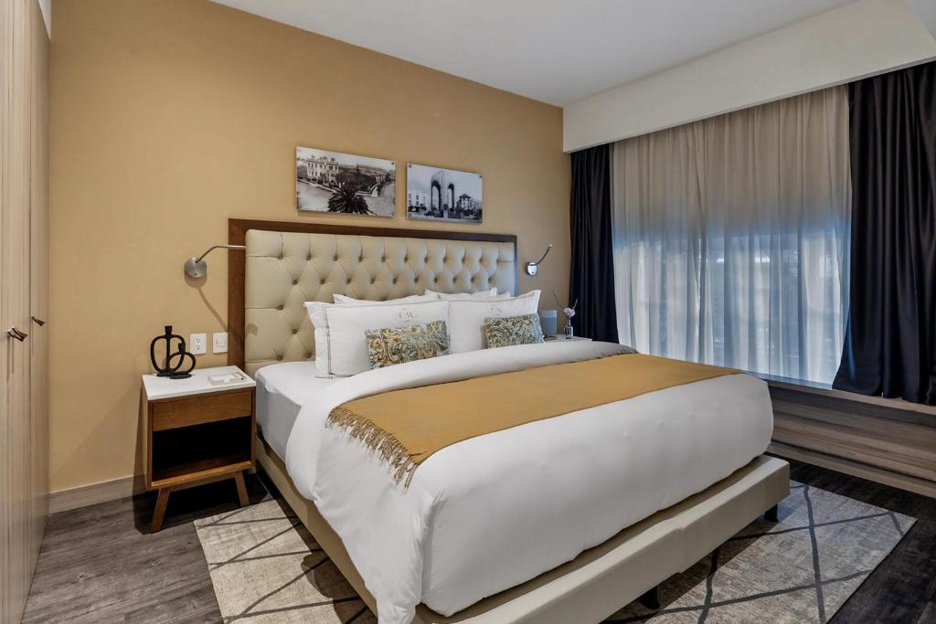 a bedroom with a large bed and a large window at Casa Malí by Dominion Boutique Hotel in Mexico City