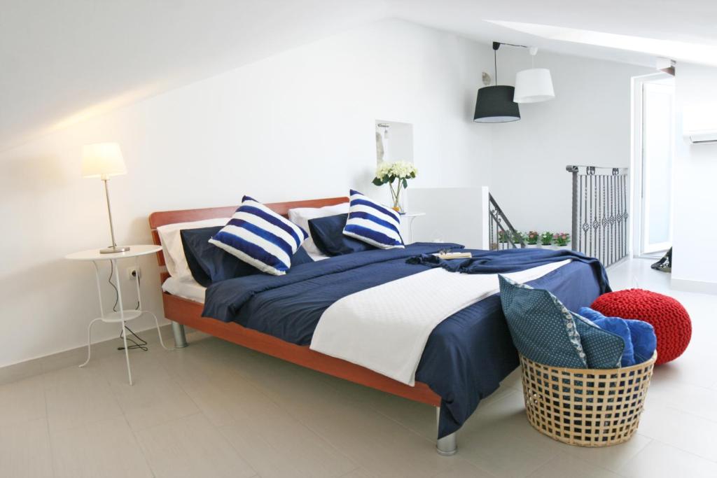 a bedroom with a bed with blue and white pillows at Apartments Stefani in Fažana