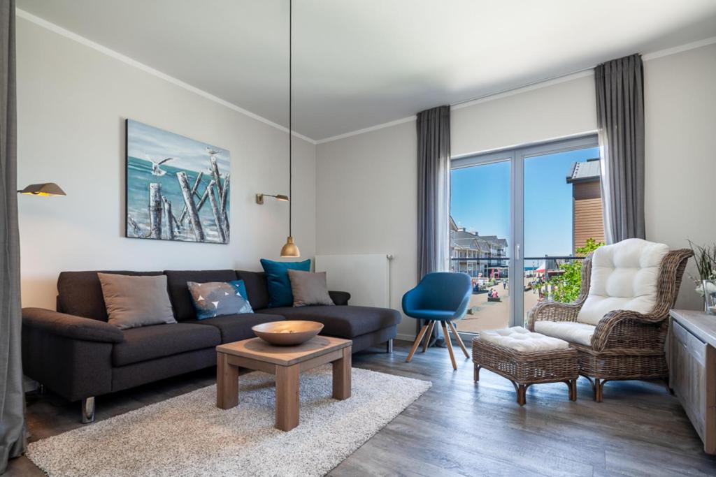 un salon avec un canapé et une table dans l'établissement Ostsee - Appartement Nr 80 "MeerSinn" im Strand Resort, à Heiligenhafen