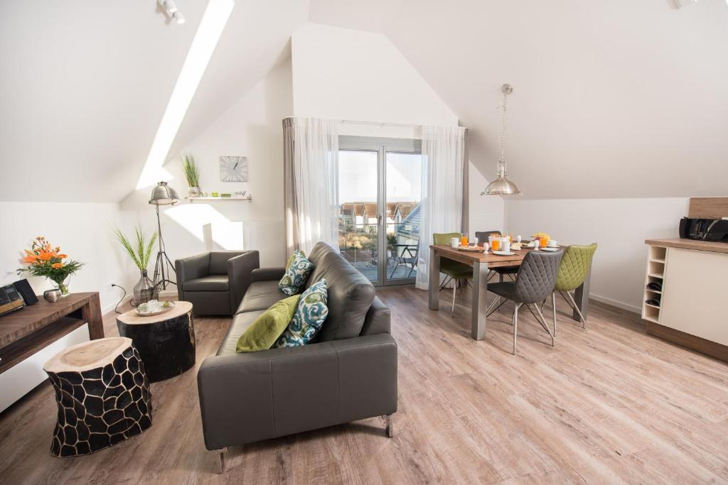 a living room with a couch and a table at Ostsee - Appartement Nr 65 "Seaside" inkl Strandkorb im Strand Resort in Heiligenhafen