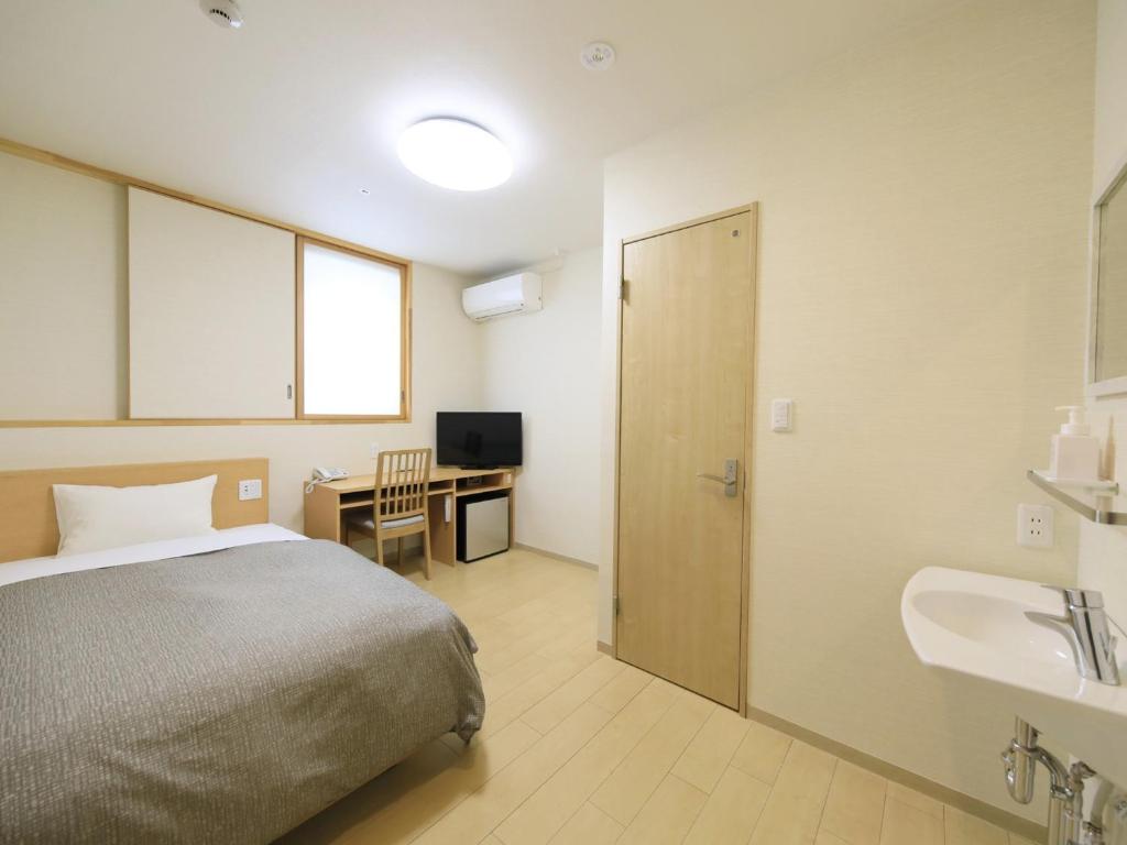 Postel nebo postele na pokoji v ubytování ステイインホテル材木栄屋