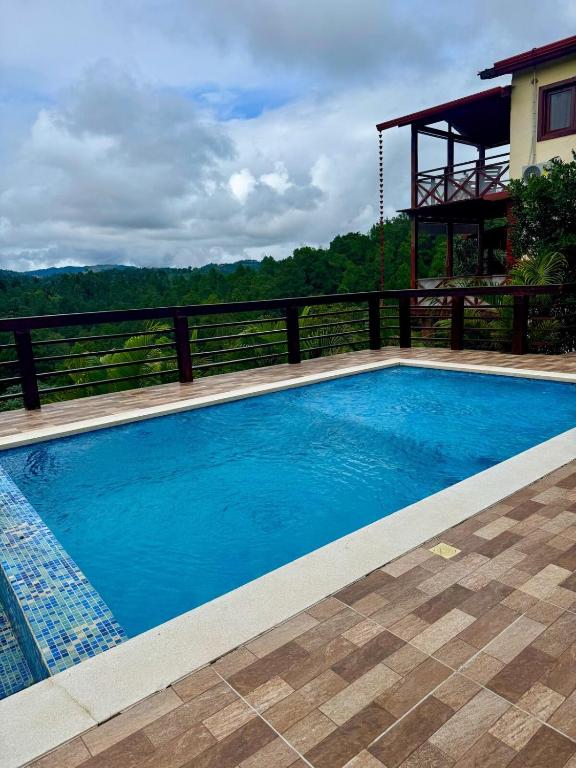 a large blue swimming pool next to a house at Alto de la Castilla in Constanza