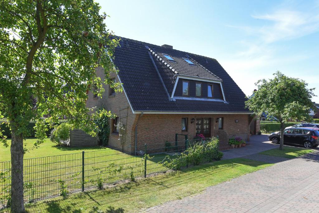 a house with a black roof and a driveway at Schleswig-Holstein Whg 01 EG li in Nieblum