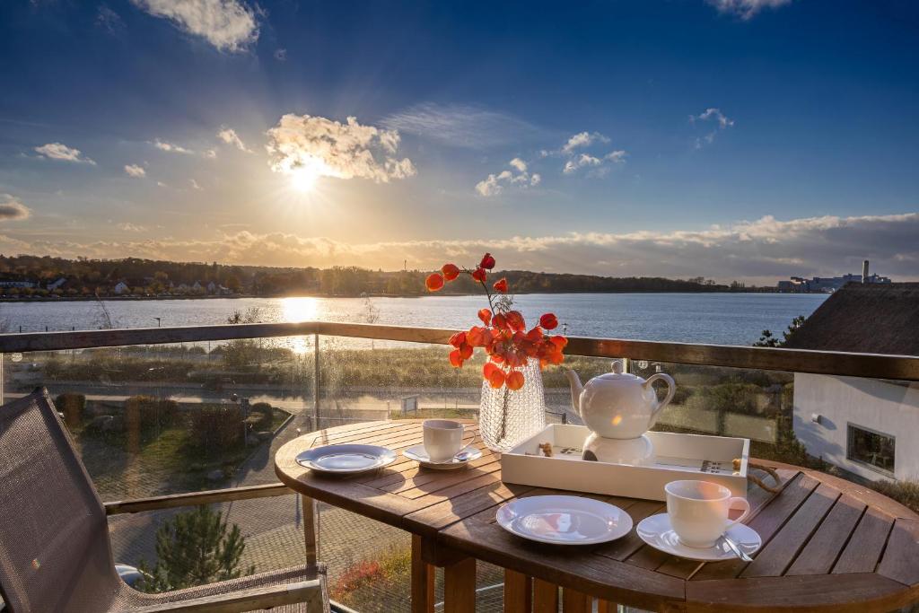 ein Tisch mit einer Vase mit Blumen auf einem Balkon in der Unterkunft Ostsee - Appartement Nr 19 "Sonnenzauber" im Strand Resort in Heiligenhafen