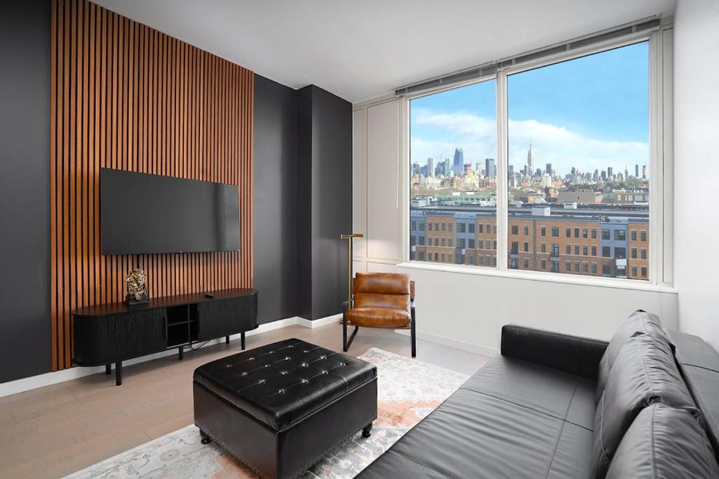 霍博肯Exclusive 1BR Apt with NYC View and Pool的带沙发和大窗户的客厅