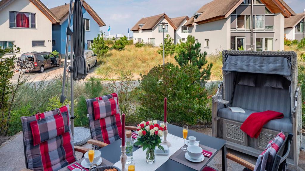 einen Tisch und Stühle auf einer Terrasse mit einem Bett in der Unterkunft Ostsee - Appartement Nr 181 "Uferschwalbe" im Strand Resort in Heiligenhafen