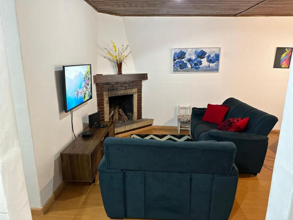 ein Wohnzimmer mit zwei Sofas und einem Kamin in der Unterkunft Solar Campos do Jordão - Perfeita para casal e Família in Campos do Jordão