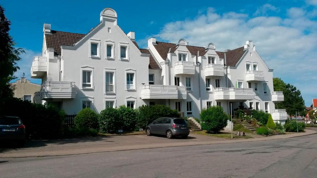 a large white house with a car parked in front at " Stadtwohnung Ausspann " in Heiligenhafen