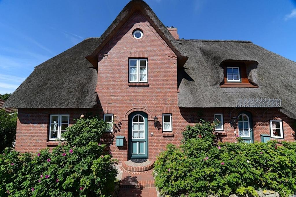 a large house with a thatched roof at Haus Strandburg in Wyk auf Föhr