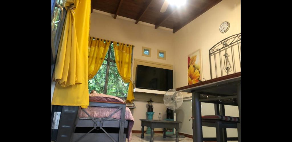 a bedroom with a bed with yellow curtains and a window at Dreams in La Plata