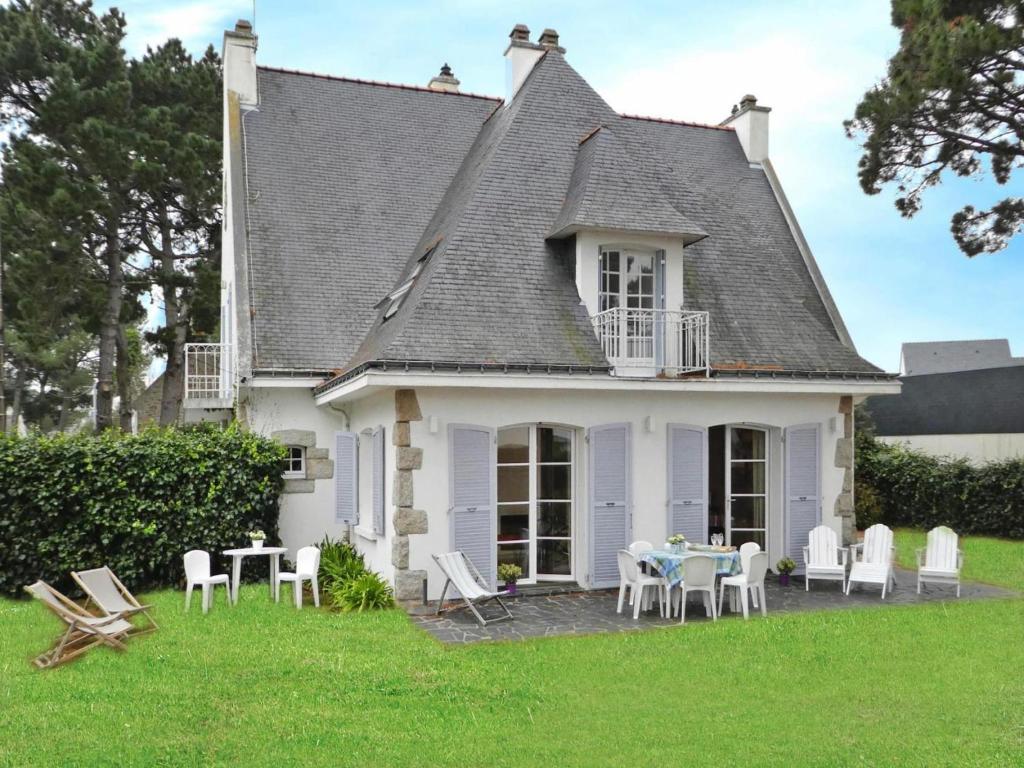 a house with a table and chairs in the yard at Holiday Home in Carnac near Sandy Beach in Carnac