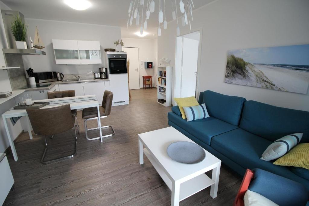 een woonkamer met een blauwe bank en een keuken bij Dock 31 in Neuhaus