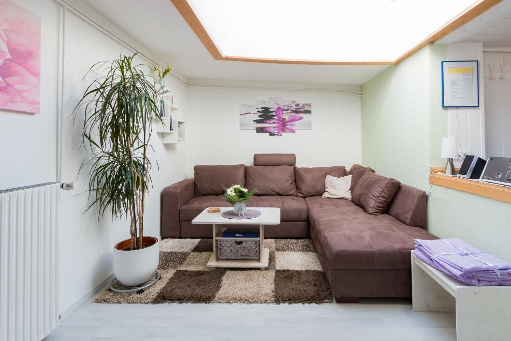 Una sala de estar con un sofá marrón y una mesa. en Daniel-Ferienhaus 2, en Eckernförde