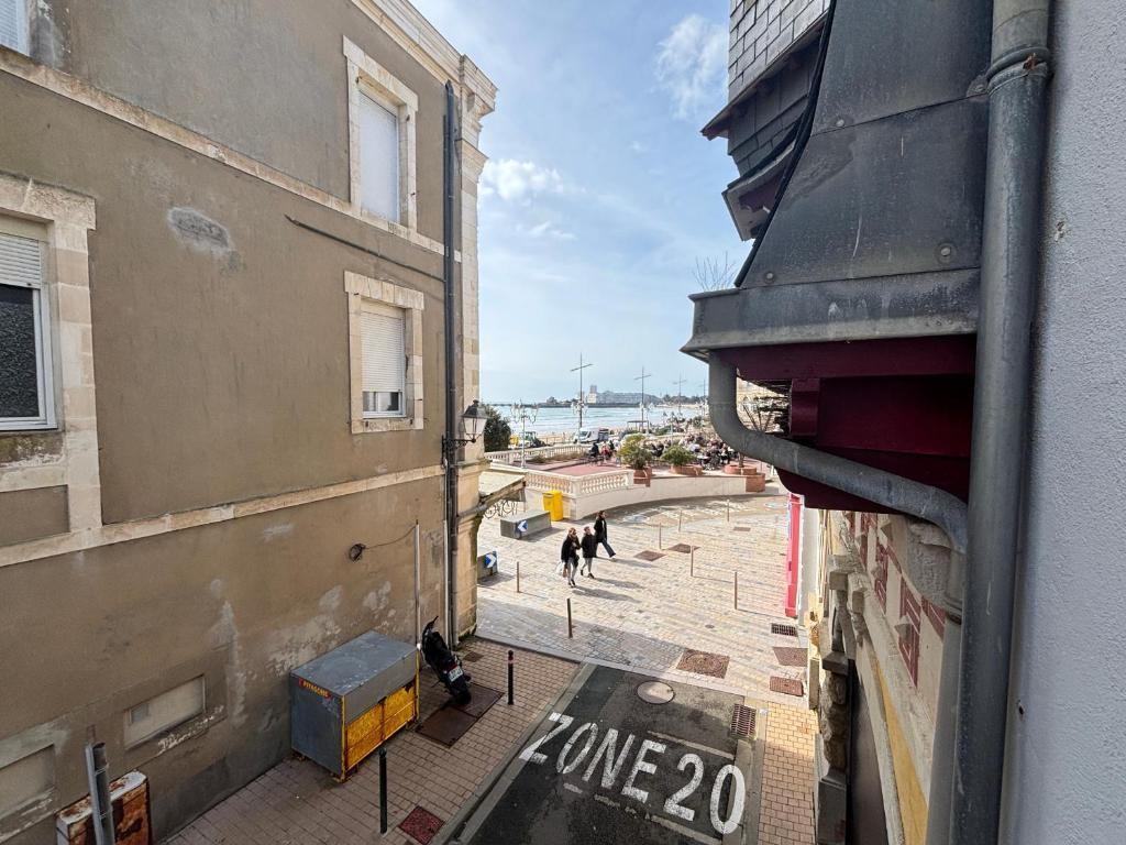 - une vue sur un bâtiment avec des personnes marchant dans une rue dans l'établissement Studio simple à 2 pas de la plage, balcon, kitchenette - FR-1-197-248, à Les Sables-dʼOlonne
