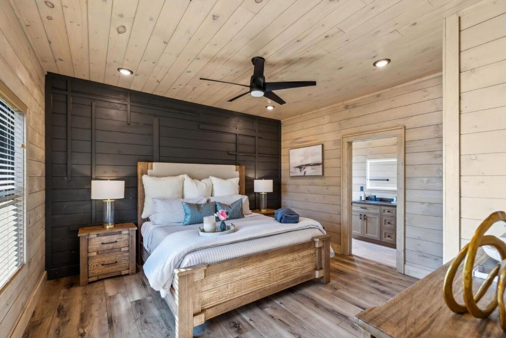 a bedroom with a bed and a ceiling fan at Honeybear Hideaways - #1 Luxury Haven Cabin with Breathtaking Mountain Views, Indoor Pool, Bowling Alley, and Golf in Pigeon Forge