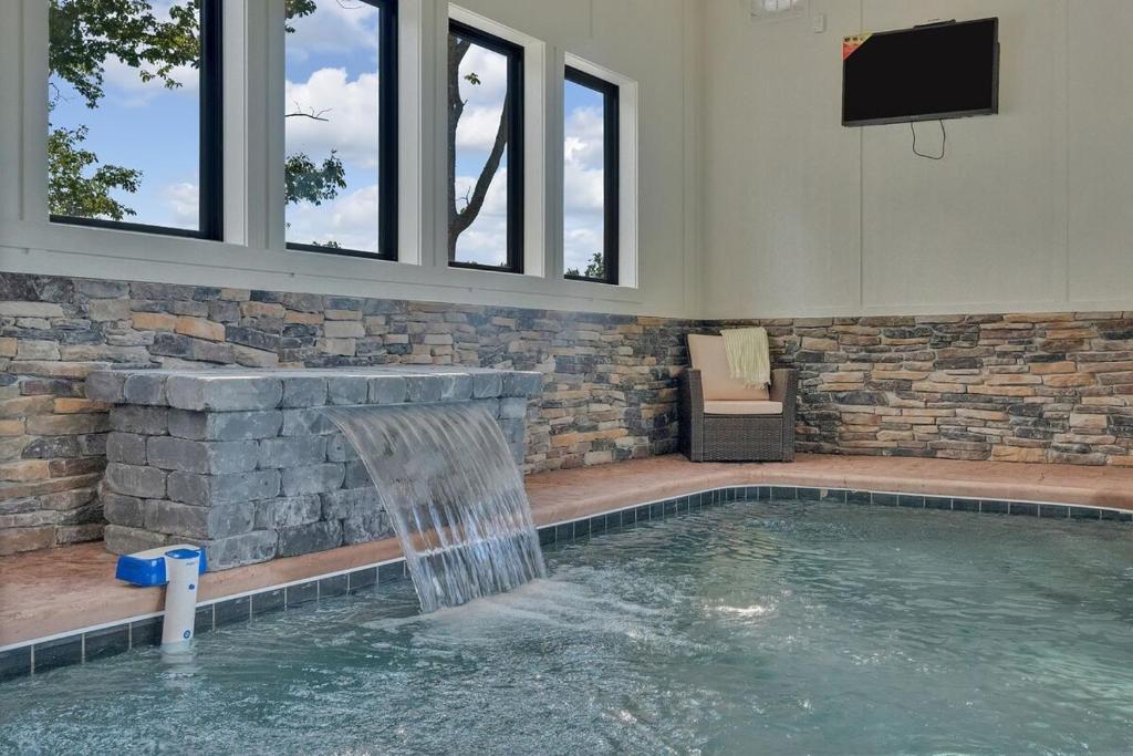 a indoor swimming pool with a water fountain at Honeybear Hideaways - #1 Luxury Haven Cabin with Breathtaking Mountain Views, Indoor Pool, Bowling Alley, and Golf in Pigeon Forge