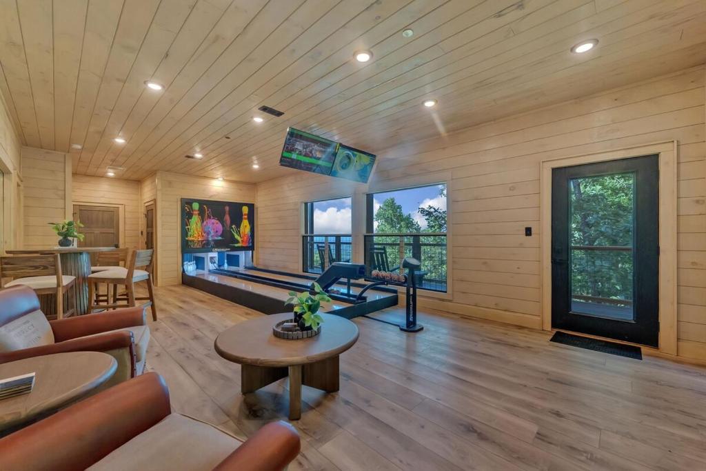 a living room with a couch and a gym at Honeybear Hideaways - #1 Luxury Haven Cabin with Breathtaking Mountain Views, Indoor Pool, Bowling Alley, and Golf in Pigeon Forge
