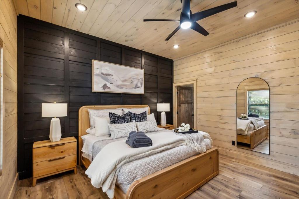 a bedroom with a bed and a ceiling fan at Honeybear Hideaways - #1 Luxury Haven Cabin with Breathtaking Mountain Views, Indoor Pool, Bowling Alley, and Golf in Pigeon Forge