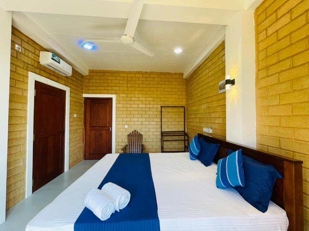 a bedroom with a large bed with blue pillows at CDR Eco Home in Weligama