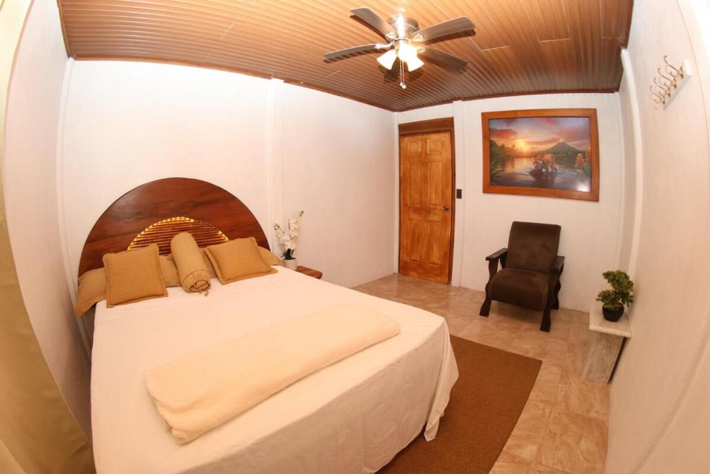 a bedroom with a bed and a ceiling fan at Arenal Garden House in Jicarito