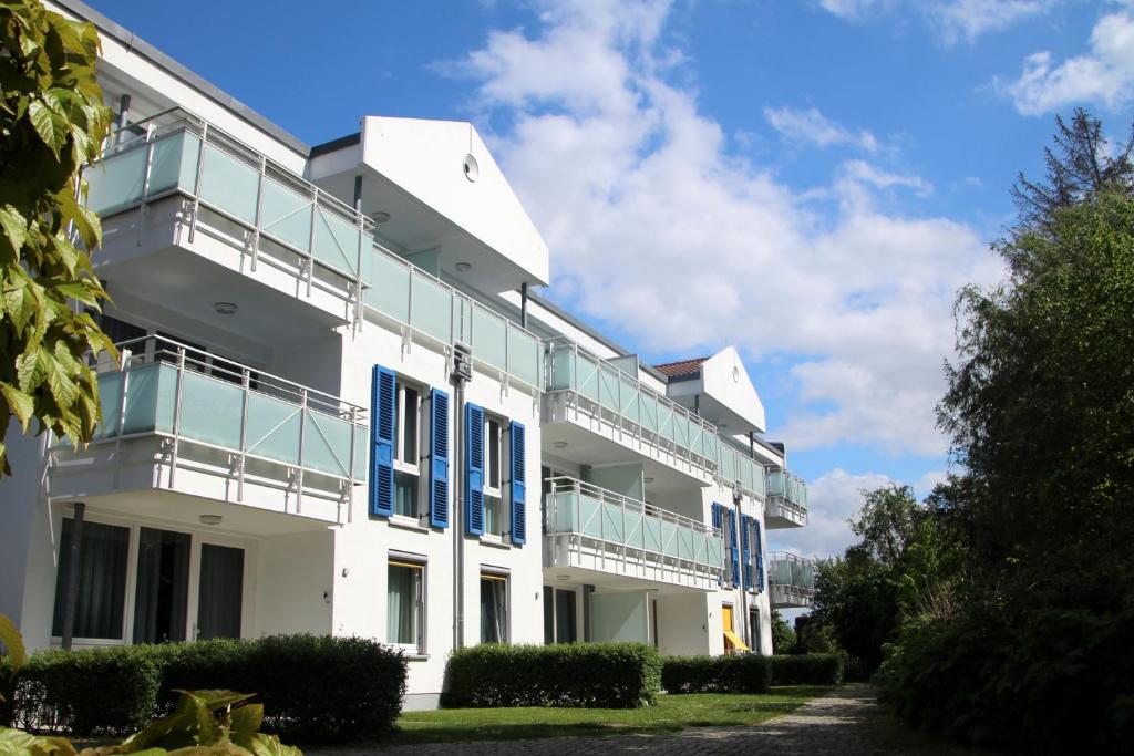 a white building with blue shutters on it at Möwe App 510 in Zingst